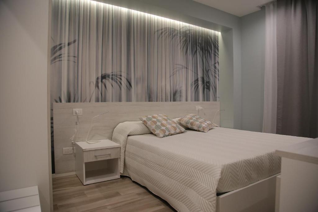 a white bedroom with a bed and a wall at B&b Antigua in Altamura