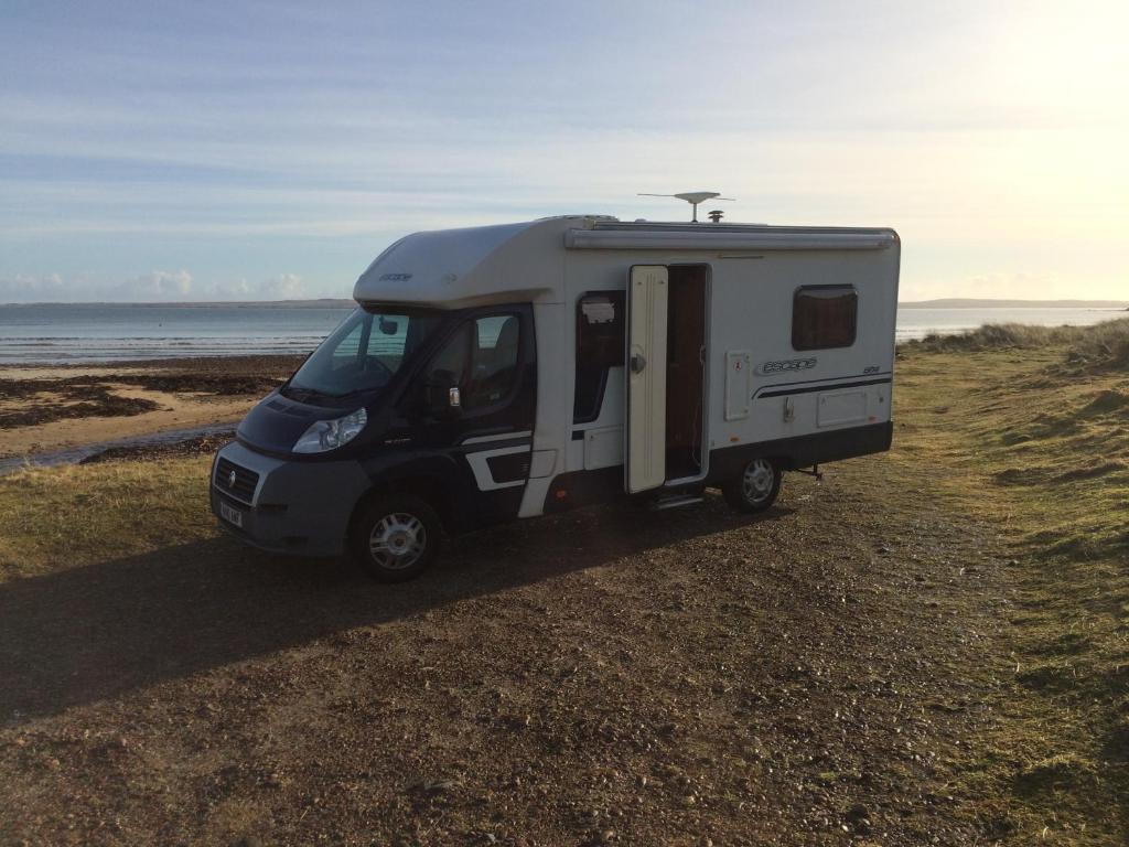 a small white caravan parked on the beach at Four Berth Motorhome Isle of Lewis in Stornoway