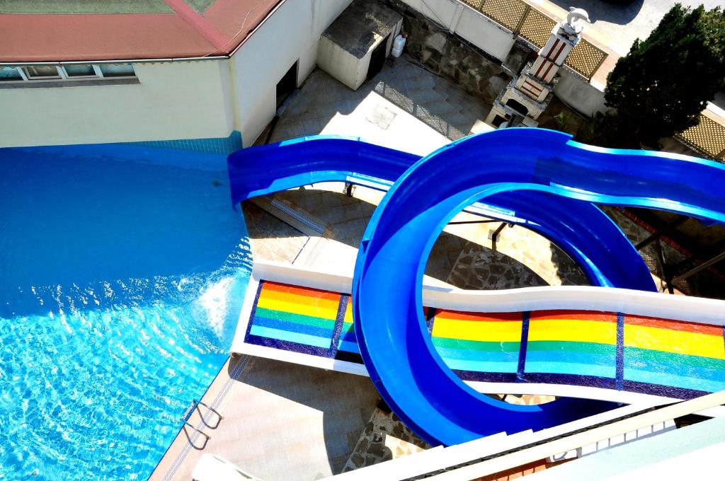a slide with a rainbow on it next to a pool at Cinar Family Suite Hotel in Side