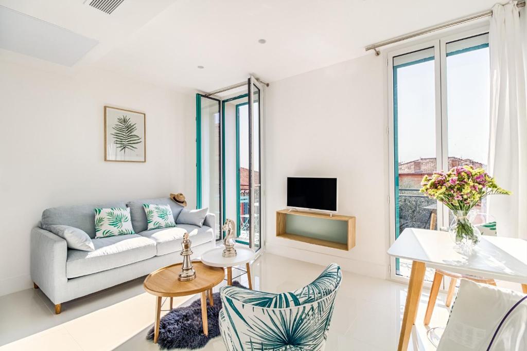 a living room with a couch and a tv at NEW ! SEA VIEW Design + Balcony 203 in Villefranche-sur-Mer