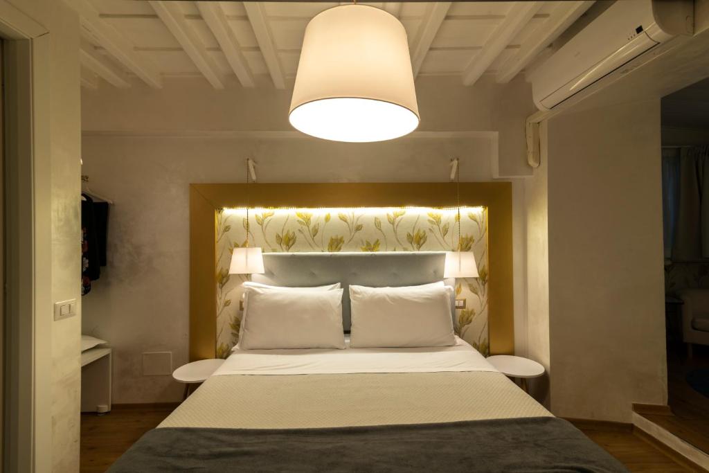 ローマにあるドルチス イン パンテオンのベッドルーム1室(大型ベッド1台、上部にライト付)