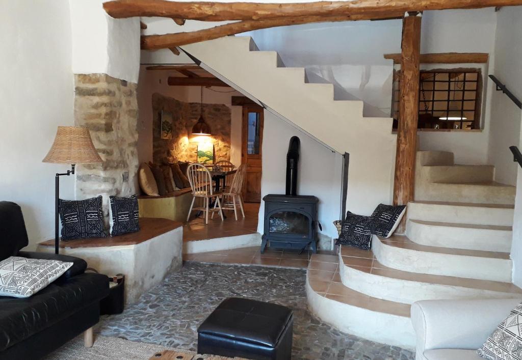 sala de estar con escaleras y estufa de leña en La Sargantana Turismo Rural, en Santa Cruz de Nogueras