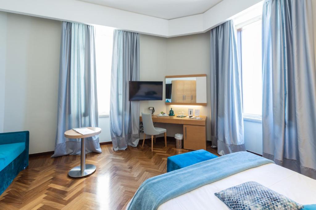 a hotel room with a bed and a desk at Palazzo Filisio - Regia Restaurant in Trani