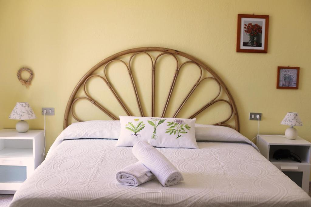 a bed with a large wooden headboard and two pillows at Pavì Delle 5 Terre in Vernazza