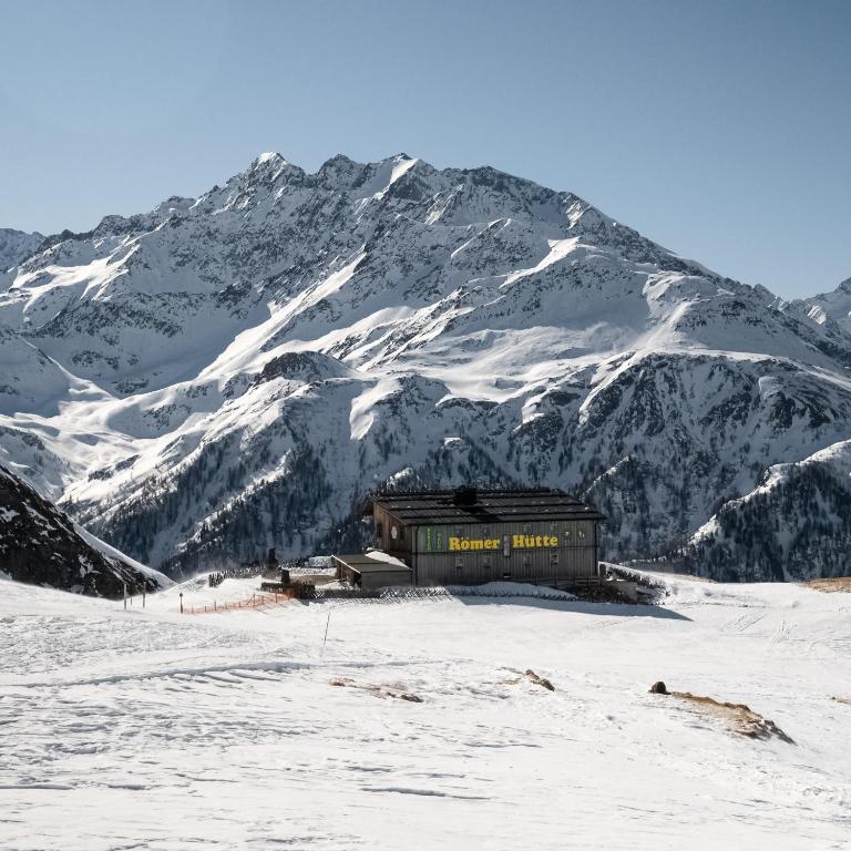 ein Gebäude im Schnee vor einem Berg in der Unterkunft Ferienhaus Römerhütte in Heiligenblut