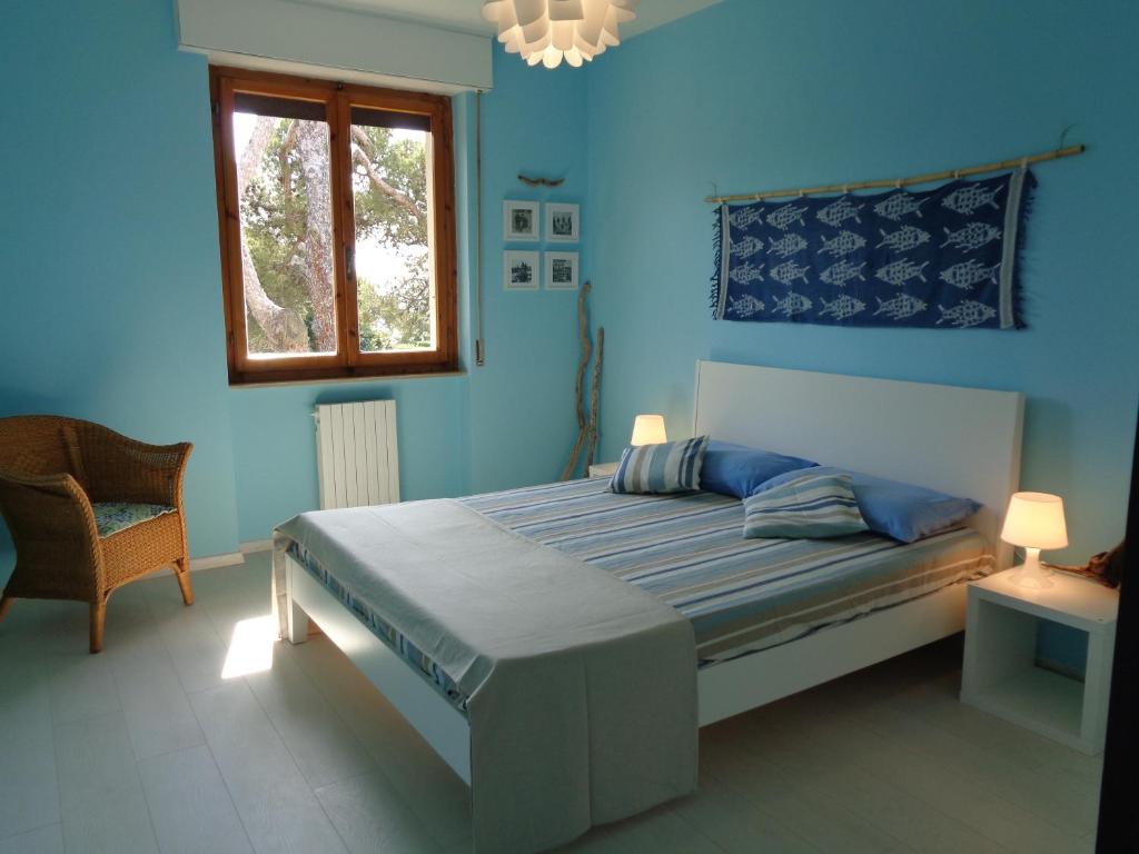 a blue bedroom with a bed and a window at La casa di Nina in Quercianella
