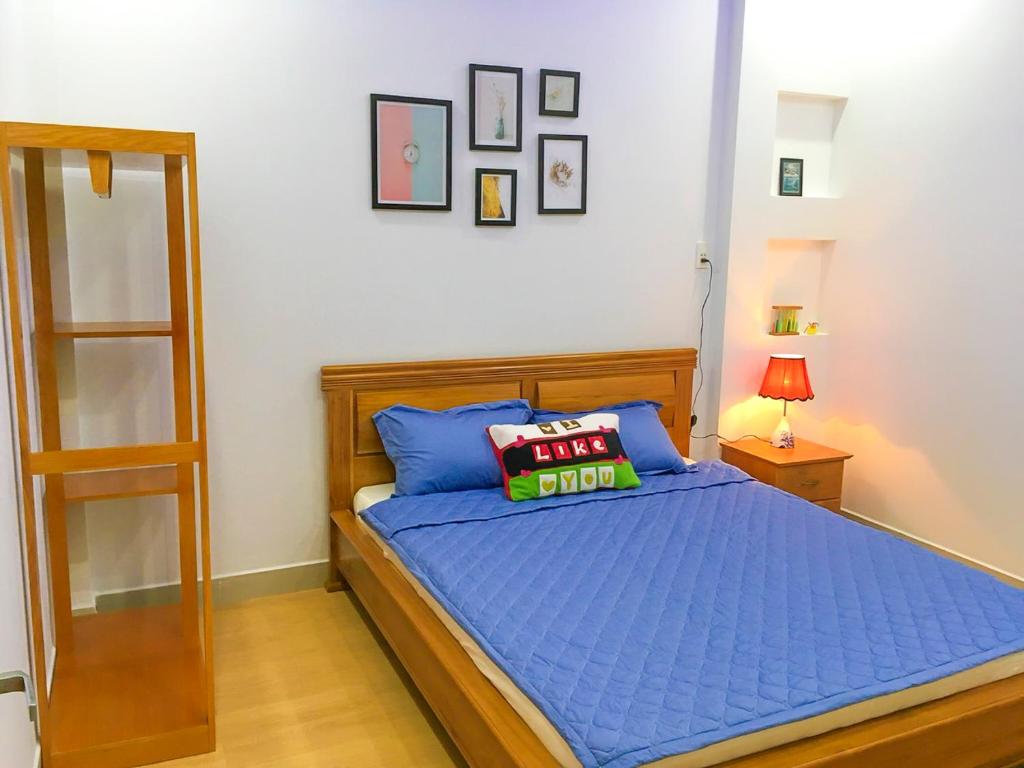 - une chambre avec un lit et une couette bleue dans l'établissement 202s Homestay, à Quy Nhơn