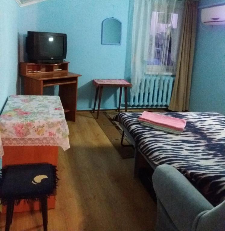 a room with a bed and a table and a tv at улица Прохоровская 12 квартира in Odesa