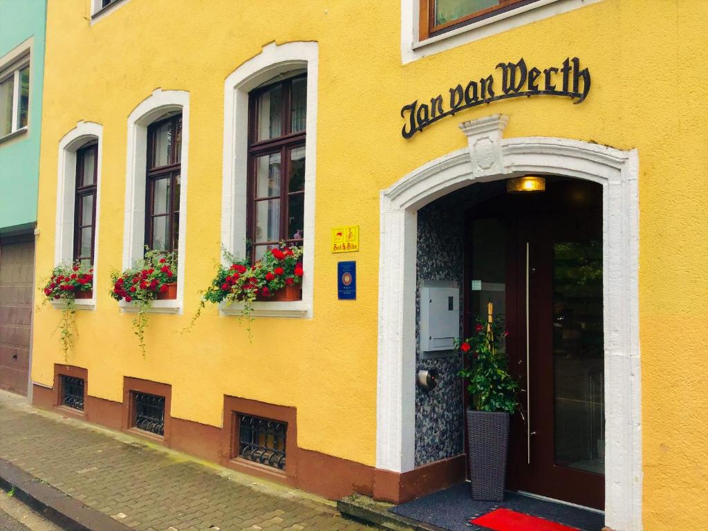 a yellow building with a sign that reads criminal mail delivery at Hotel Jan van Werth in Koblenz