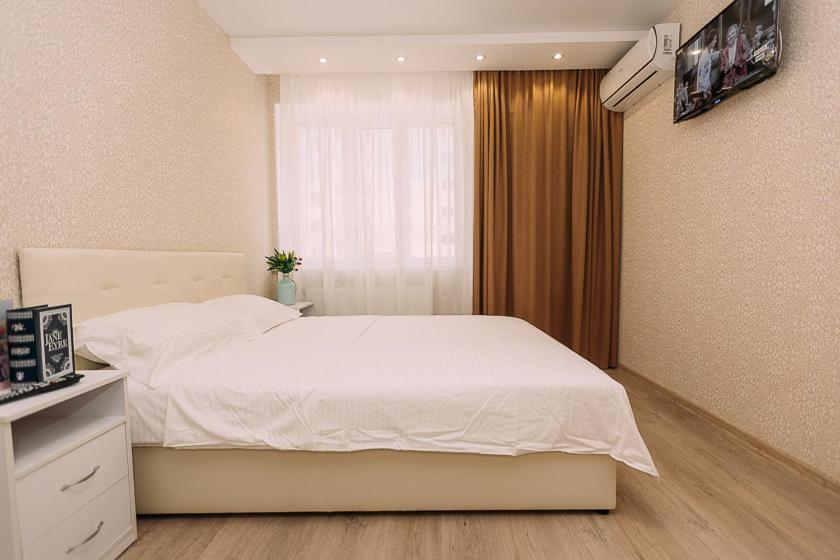 Un dormitorio con una cama blanca y una ventana. en Люкс апартамента на Харьковской возле ТЦ Лавина, en Sumy