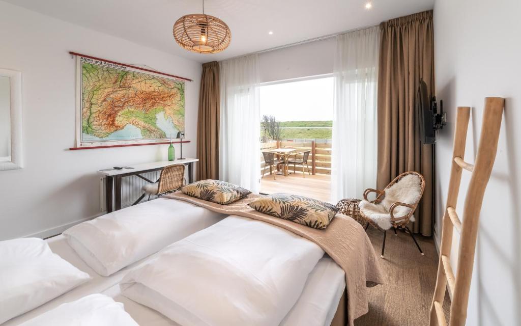 a bedroom with a bed and a large window at Het Vlielandhotel in Oost-Vlieland