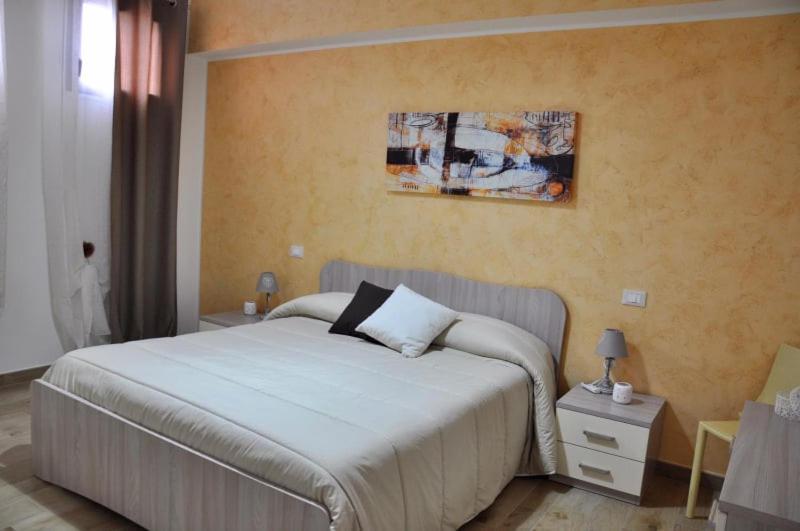1 dormitorio con 1 cama y una pintura en la pared en House Le Fontanelle en Lizzano