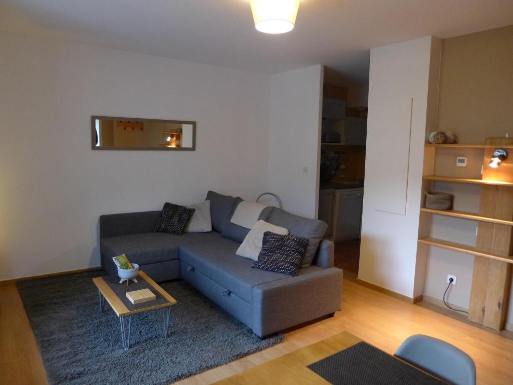 a living room with a blue couch and a table at Confortable appartement T2 cabine Loudenvielle in Loudenvielle