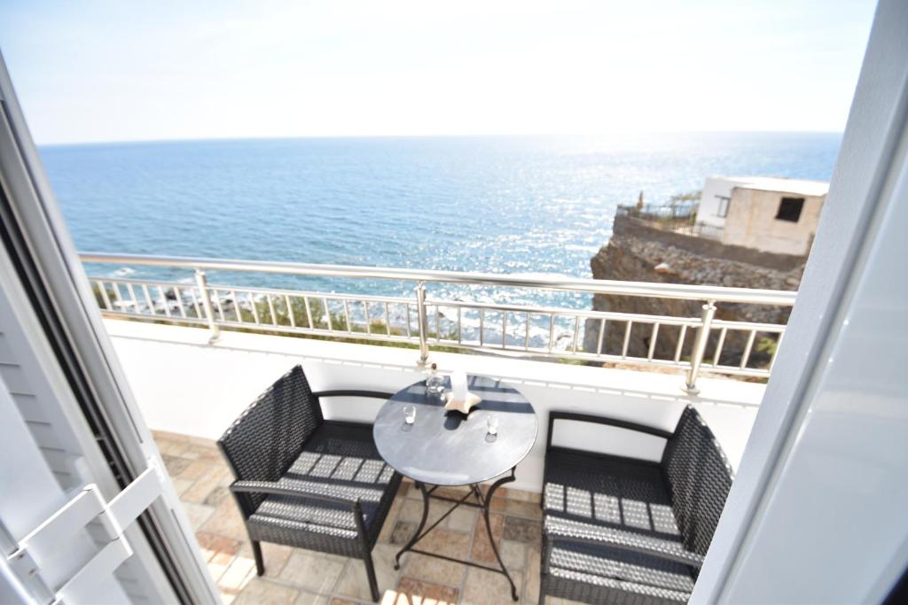 a balcony with a table and chairs and the ocean at House With View in Paránimfoi