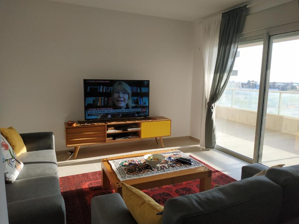 a living room with a couch and a tv at עכו דירה חדשה ליד הים- Akko-brand new apartment in Acre