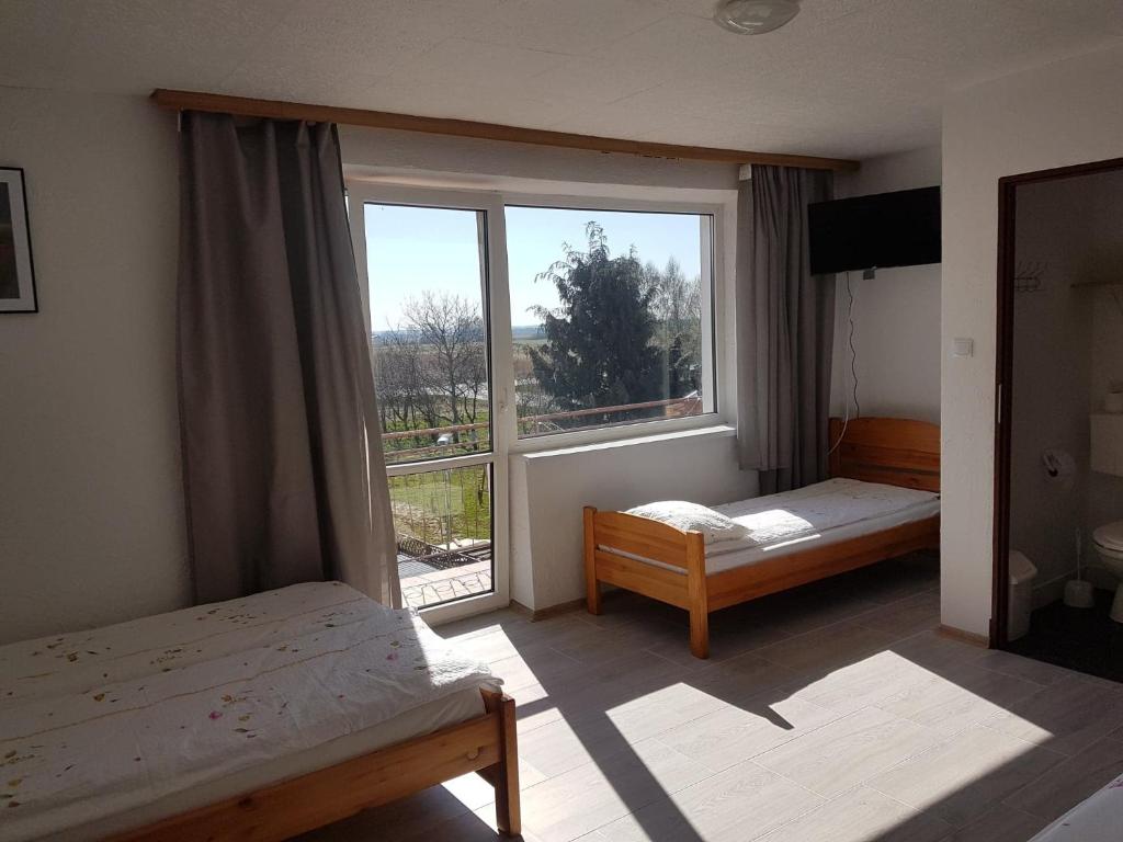 1 dormitorio con 2 camas y ventana grande en Marynarska 19, en Darłówko