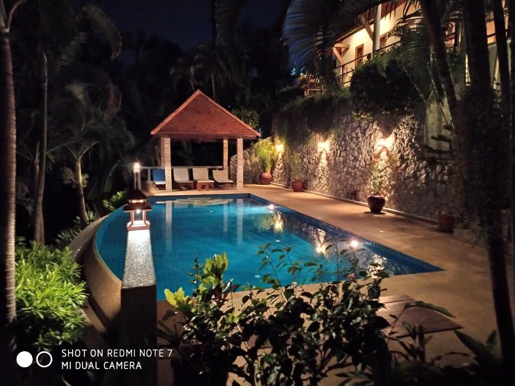 a swimming pool at night with a gazebo at Baiyok Villa seaview and edge pool in Patong Beach