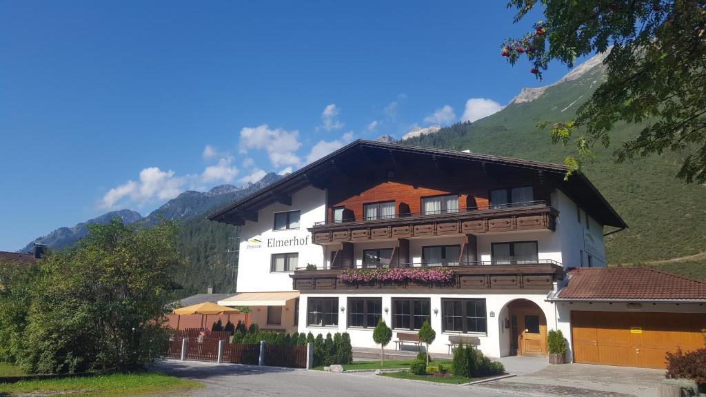 a large white building with a mountain in the background at Pension Elmerhof in Elmen