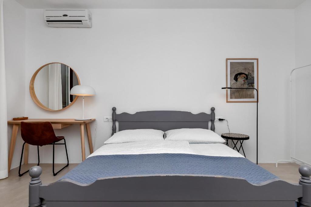 um quarto com uma cama grande e um espelho em Apartments & Rooms Rica em Makarska