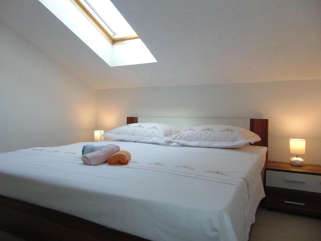 a bedroom with a large white bed with a skylight at Apartment 3 in Zadar