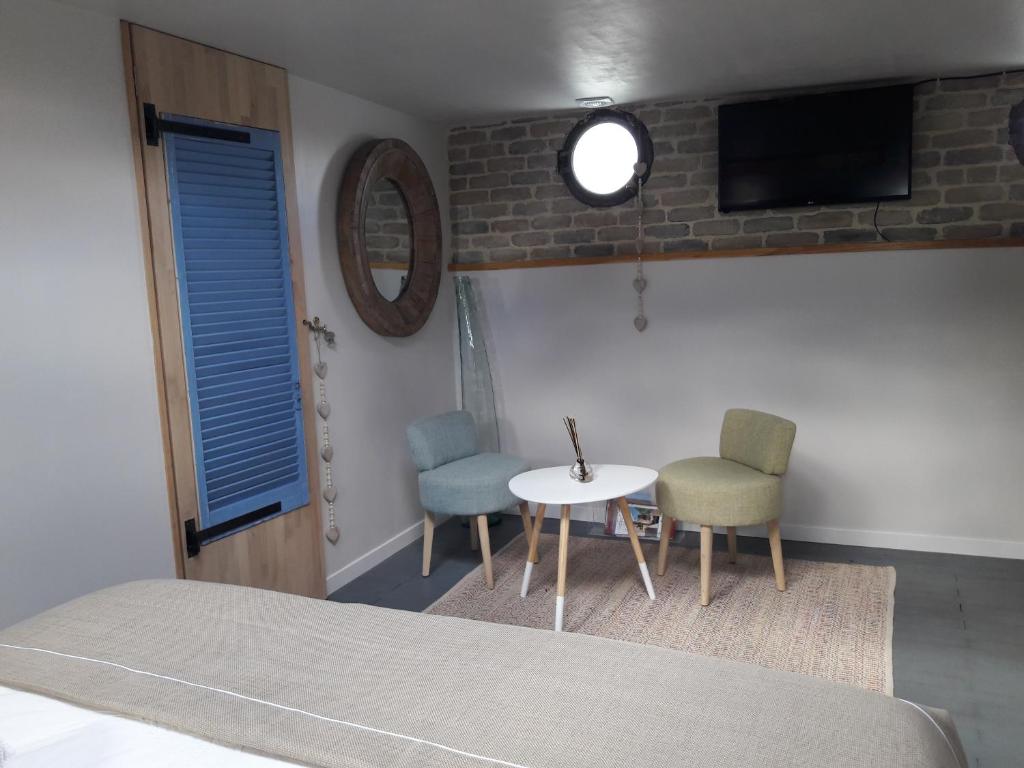 a room with a table and two chairs and a tv at Péniche La Belle Aimée in Aigues-Mortes
