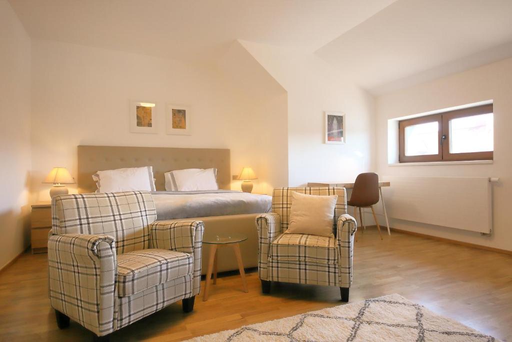 una camera con un letto e due sedie di Prague Expat House a Praga