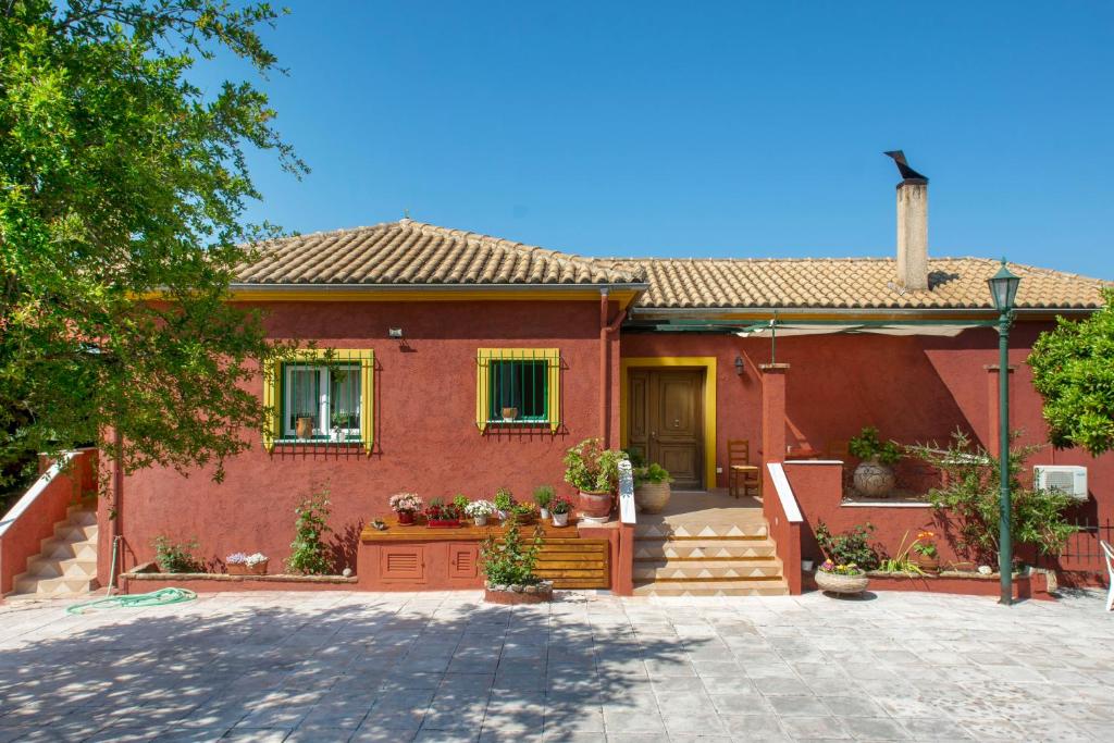 a red brick house with yellow windows and stairs at Kornata Country House in Kornáta