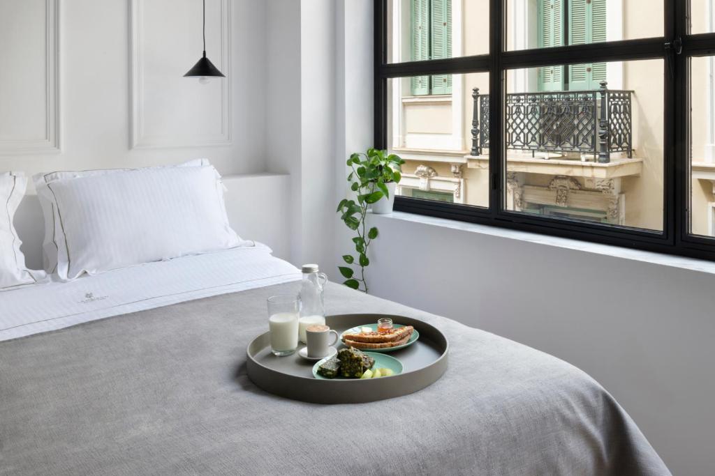 雅典的住宿－La Maison Athenes，卧室床上的食品托盘