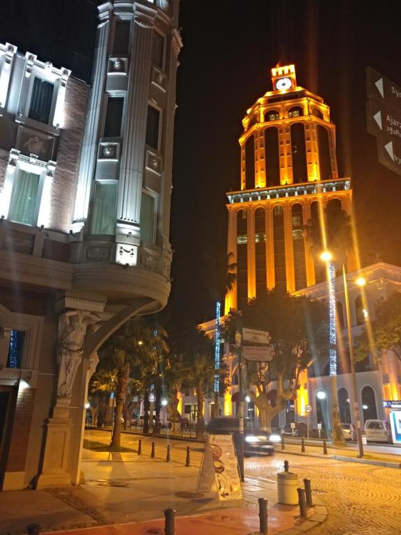 un gran edificio con una torre de reloj por la noche en Batumi apartment in front of Sheraton en Batumi