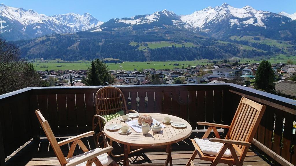 a table and chairs on a balcony with mountains at Ferienhaus Hohe Tauern in Piesendorf in Piesendorf