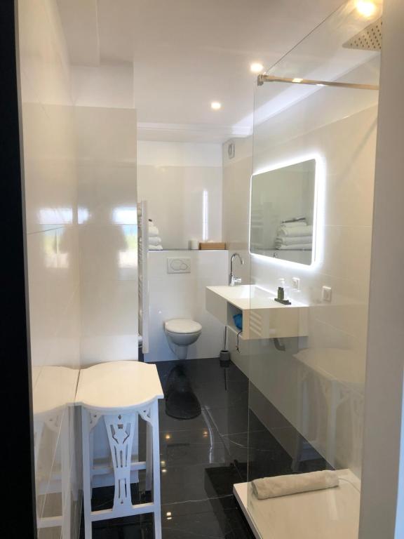a white bathroom with a sink and a toilet at Hôtel Le Mistral in Marseille
