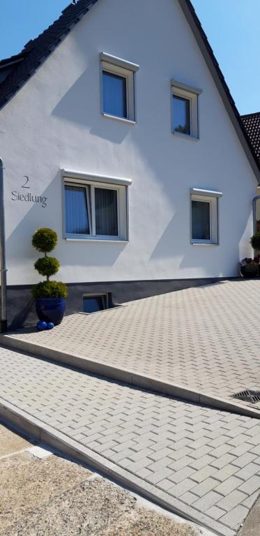 a white building with a bonsai tree in front of it at Weinbergblick in Ramsthal