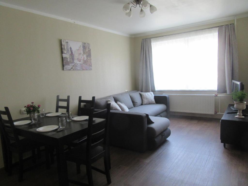 ein Wohnzimmer mit einem Sofa und einem Tisch in der Unterkunft Family Apartment in Riga