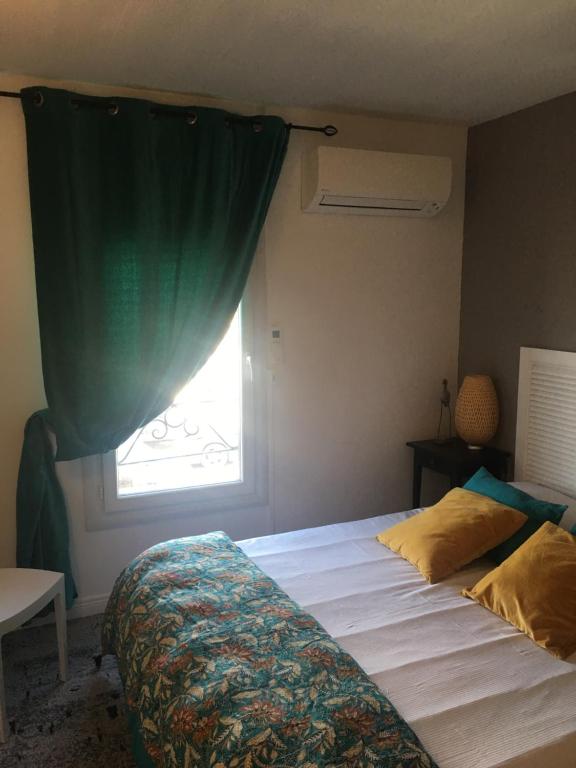 a bedroom with a large bed with a window at Hôtel Le Mistral in Marseille