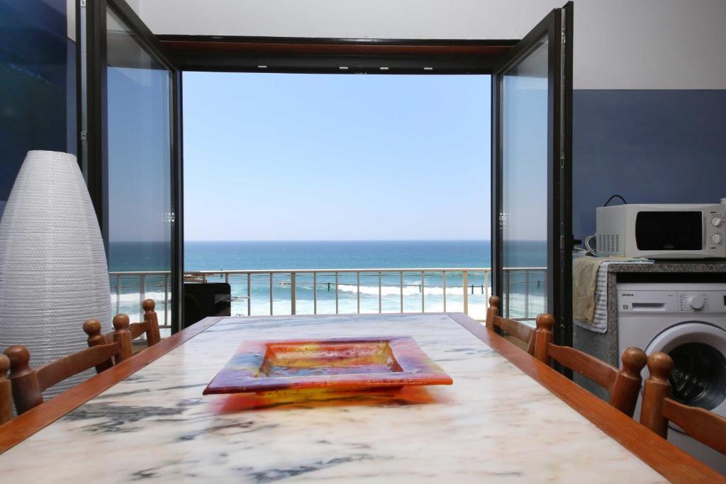 sala de estar con vistas al océano en Prime Oceanfront Apartment, en Ericeira