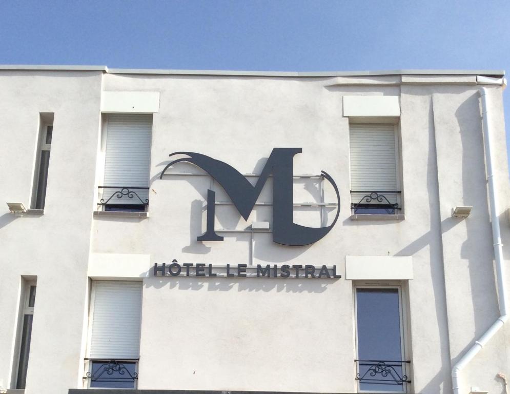 a building with a sign on the side of it at Hôtel Le Mistral in Marseille