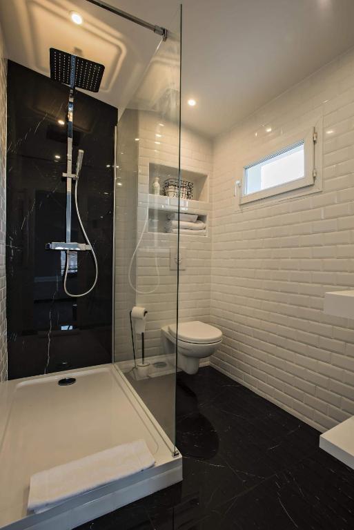 a bathroom with a shower and a tub and a toilet at Hôtel Le Mistral in Marseille