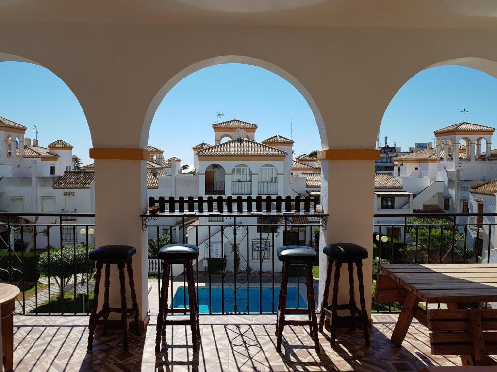 eine Terrasse mit Stühlen und Poolblick in der Unterkunft Дуплекс " Torre Gala" Playa Flamenca in Playa Flamenca