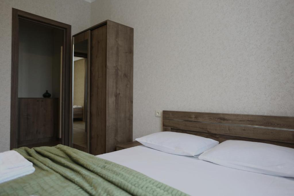 una camera da letto con un letto e uno specchio di Ia's Guest House a Kazbegi