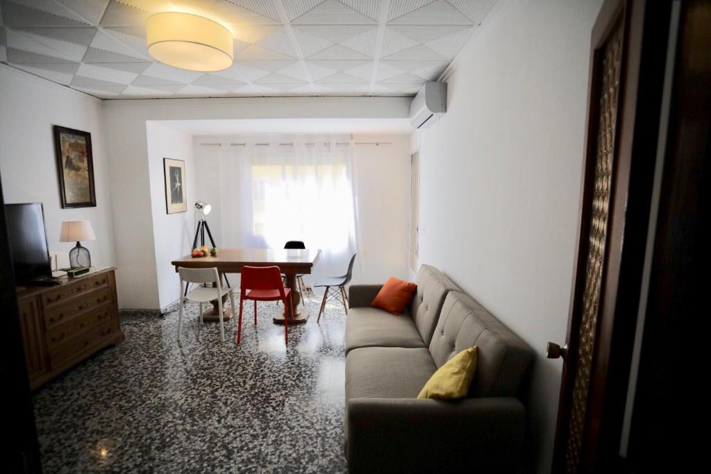 Gandia Retro Apartament في غانديا: غرفة معيشة مع أريكة وطاولة