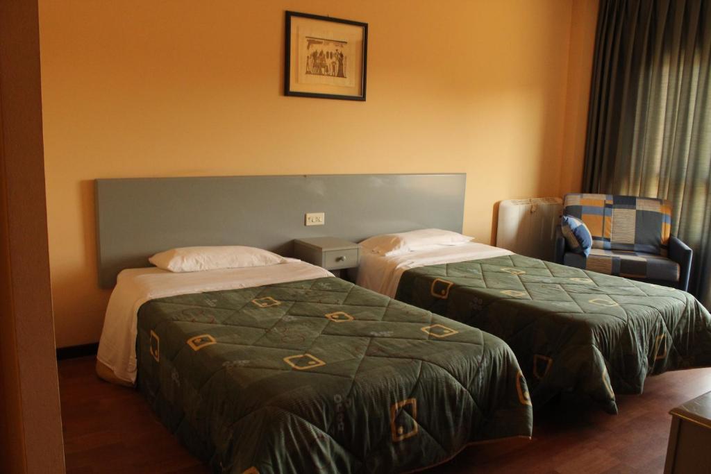 a bedroom with two beds and a desk at Hotel Baccus in Carballino