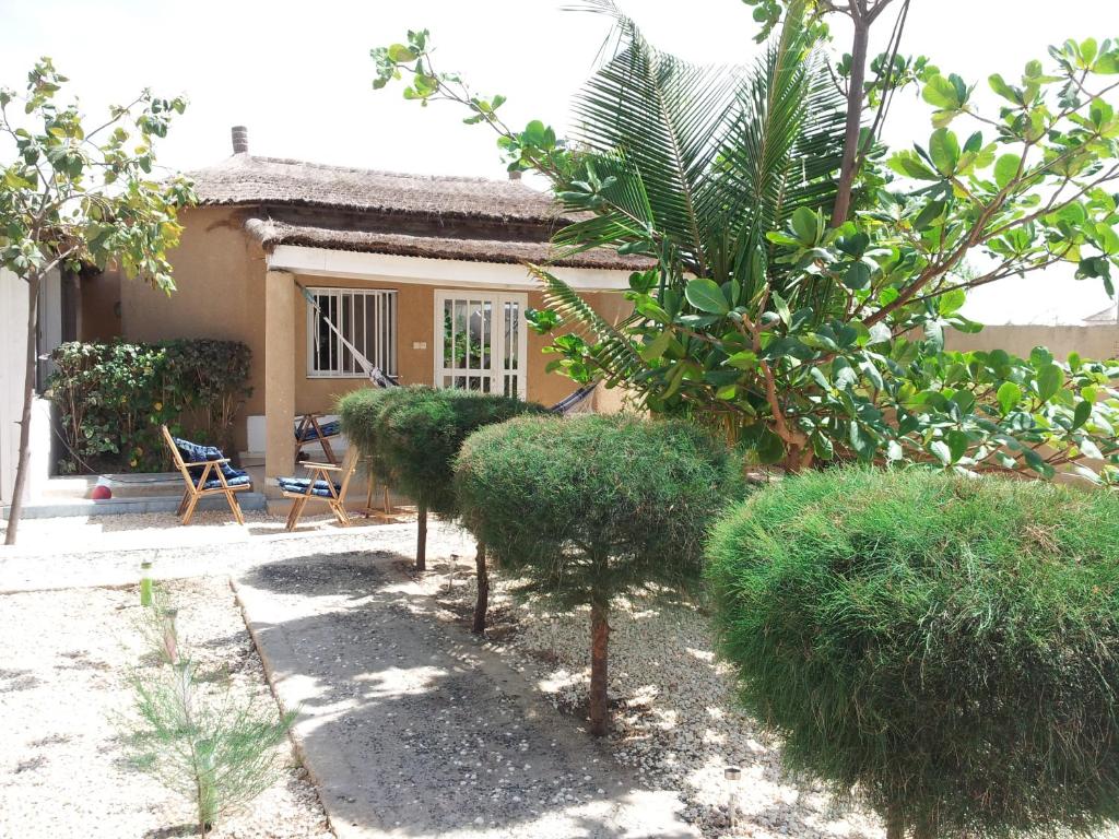 un jardín con arbustos y una casa en Maison de Vacances à Foundiougne, Sénégal, en Poundiougne