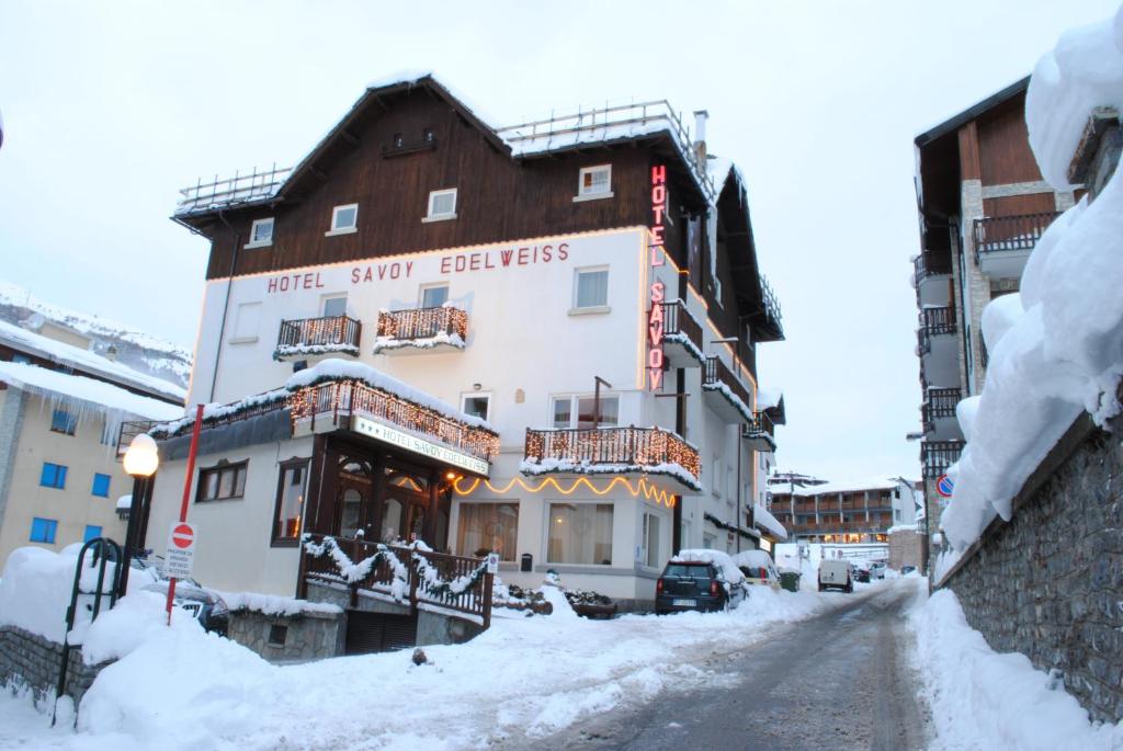 a building on a street with snow on the ground at Hotel Savoy Sestriere in Sestriere