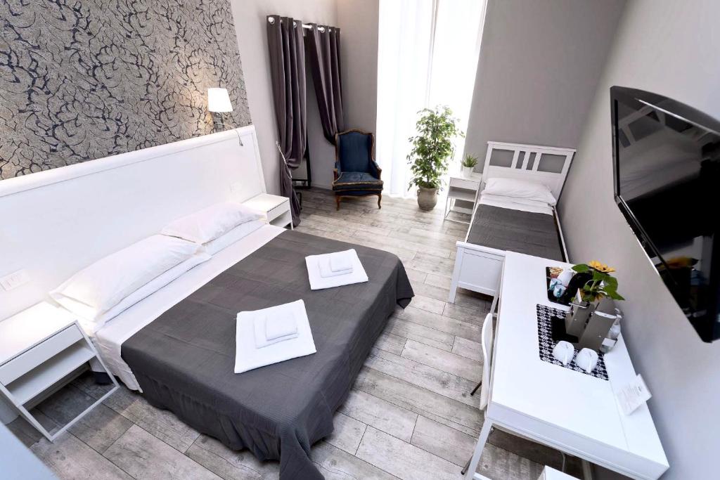 Habitación con cama, mesa y TV. en Bed And Best, en Roma