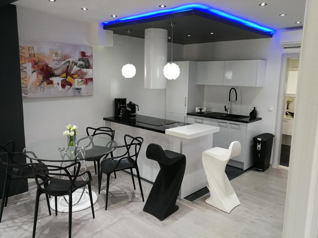 a kitchen with a table and chairs and a blue light at Palladium II City Center Apartments in Makarska