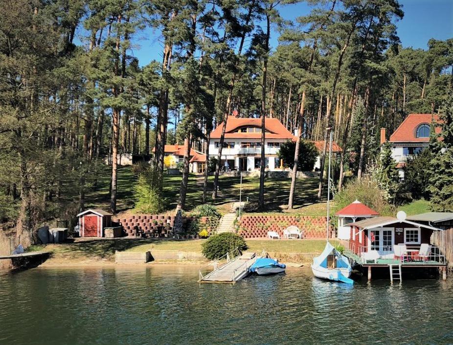 a house on the shore of a lake with boats in the water at Ferienhaus Hanna in Waren