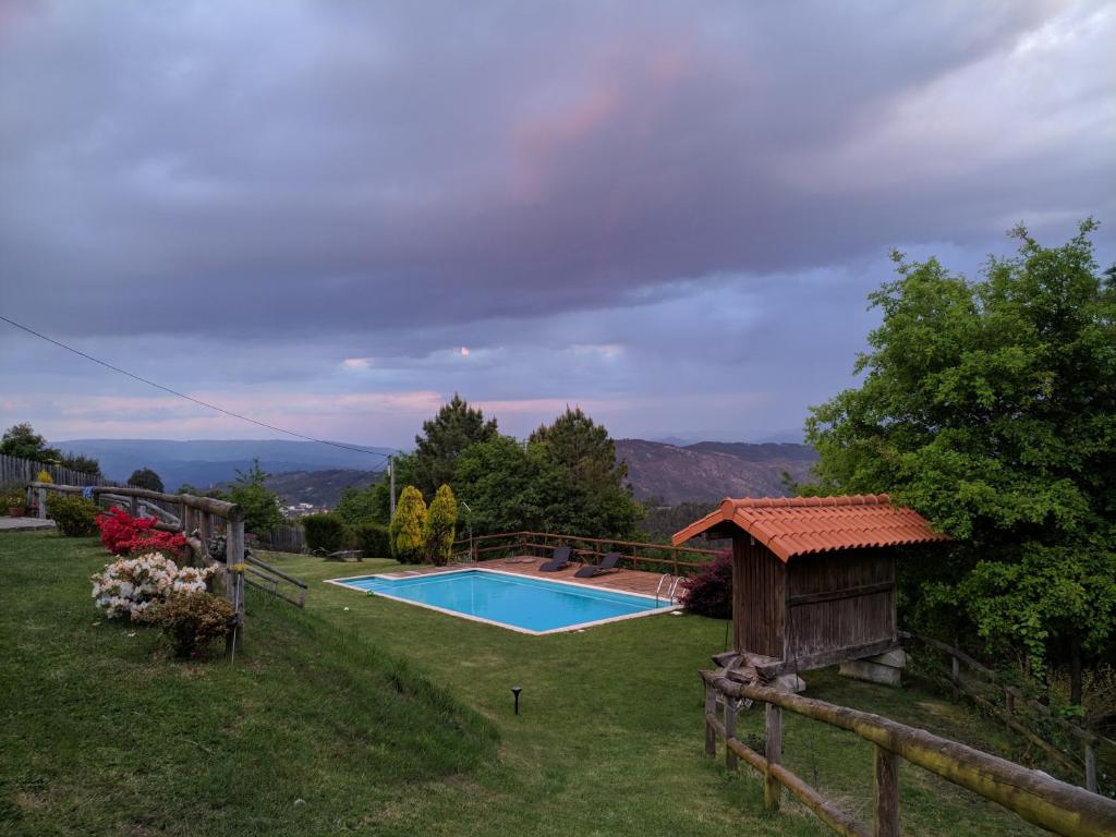 Un patio trasero con piscina y una casa. en Quinta do Espigueiro, en Celorico de Basto