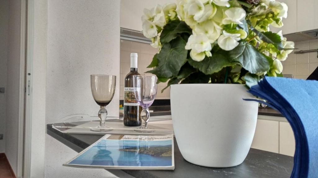 una mesa con dos vasos y un jarrón con flores en Casa Marcone, en Deiva Marina