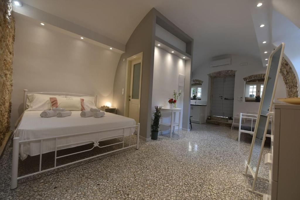 a bedroom with a bed and a living room at Yiasemi Corfu Luxury Studio in Corfu Town