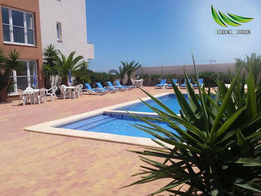 une piscine avec des chaises longues et un bâtiment dans l'établissement Résidence Saradon La Zenia Boulevard, à Los Dolses